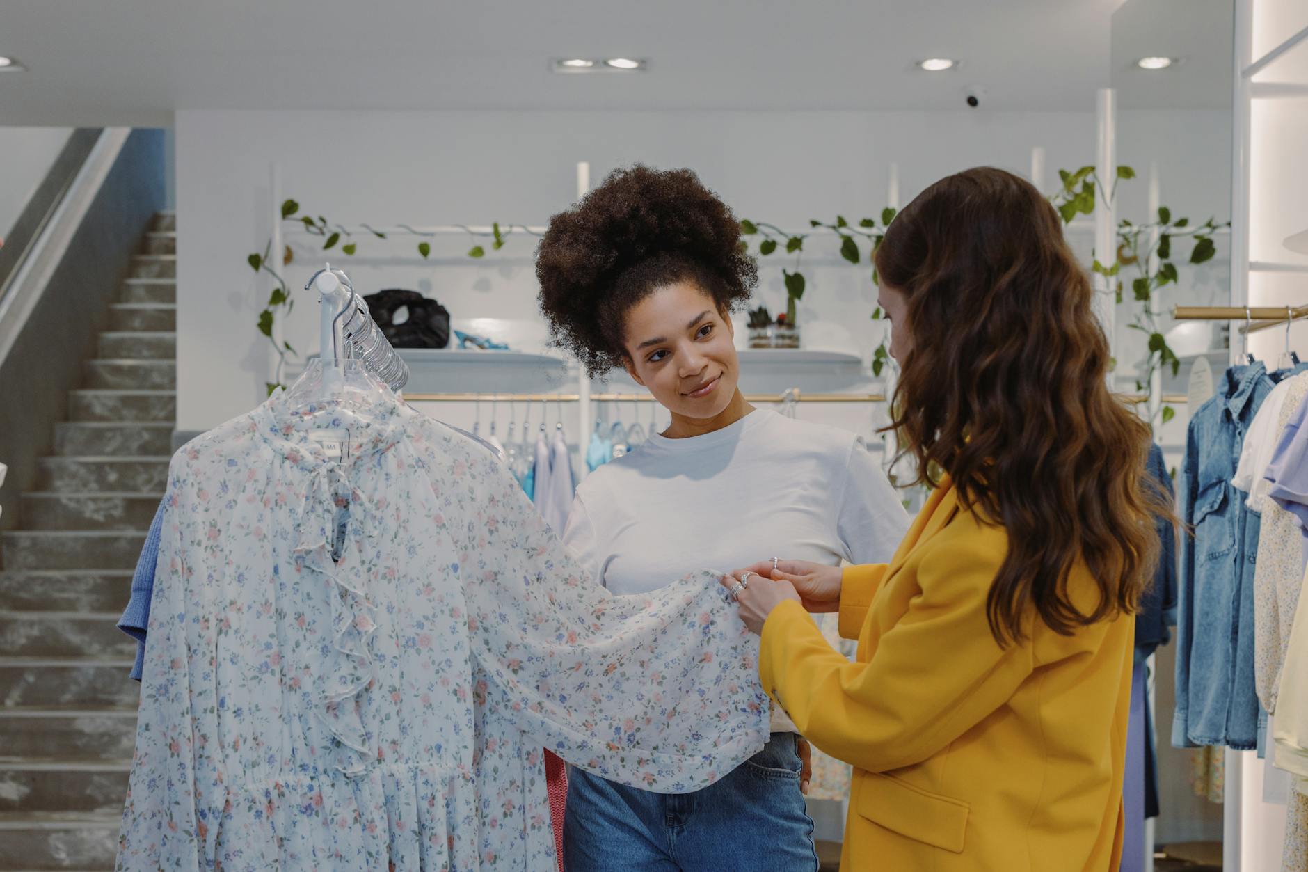 women looking at a floral dress inside a boutique